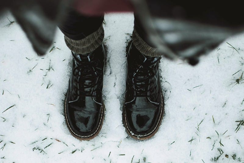 Frau trägt Winterstiefel im Schnee